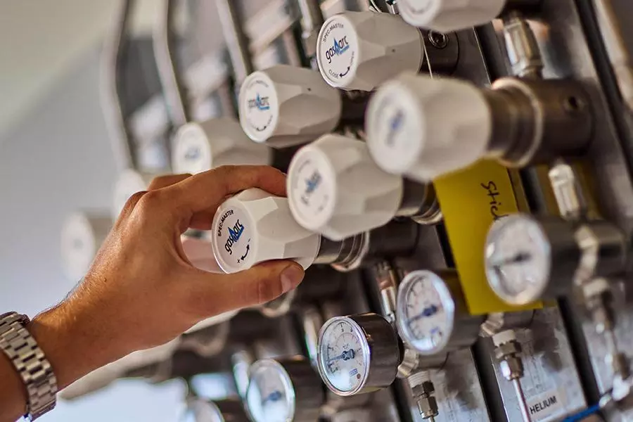 photo of researcher hand in catalysis hub labs at gas pipes